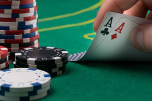 hand raises for two winning cards on a green poker table